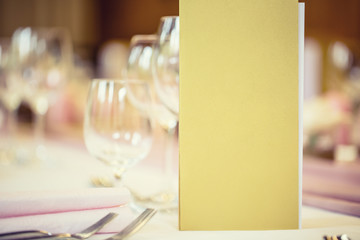 Served table with menu brochure in restaurant, closeup. Free space for your text or information