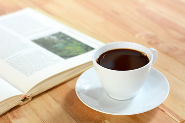 Coffee cup with book on wood table