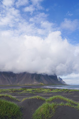 Mountains of the Vestrahorn with cloud on top holding,Iceland
