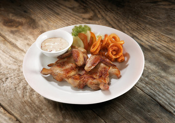 Fried chicken wings with curly fries and mayonnaise