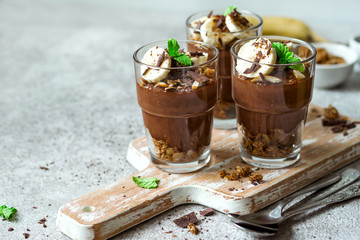 Chocolate pudding with chia and banana in glasses. Healthy dessert or breakfast