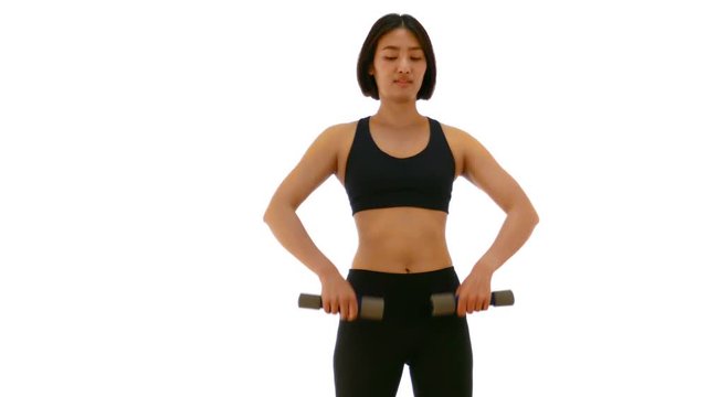 Pretty Thai Asian sportswoman is lifting dumbell in both arm standing V raise posture. Weight exercise cardio workout in white isolated background in fitness concept 