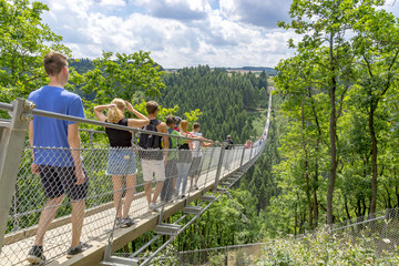 Moersdorf, Rhineland-Palatinate/ Germany July 18 2017: Germany's largest suspension bridge Geierlay in Moersdorf at Hunsrueck mountains - obrazy, fototapety, plakaty