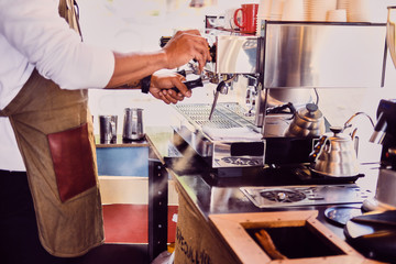 A man pouring coffee in a restaurant.