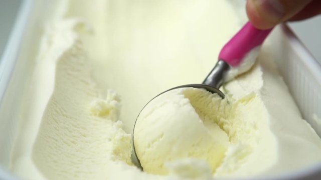vanilla ice cream being scooped out of container 