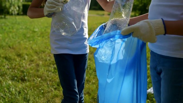 Scaled up look on children cleaning trash in park