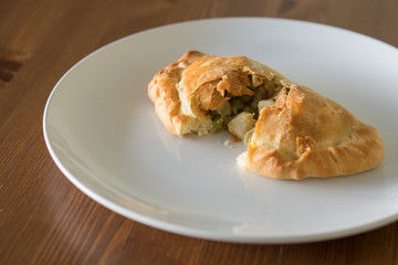 hand broken pasty on a white plate