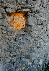 Sun shining through a hole in a stone wall