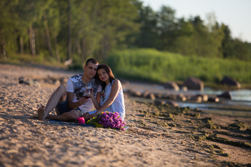 A young couple in love, on the shore of the Bay at sunset