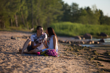 A young couple in love, on the shore of the Bay at sunset