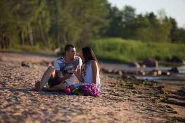 A young couple in love, on the shore of the Bay at sunset