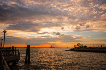 絶景、ハドソンリバーの夕暮れ / New York のシンボル自由の女神の向こうNew Jersey に夕日が沈み、美しい夕焼け雲が広がります。