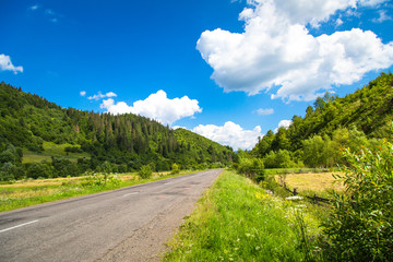 Fototapeta na wymiar Mountain road in summer. Beautiful landscape hill forest and blue sky.