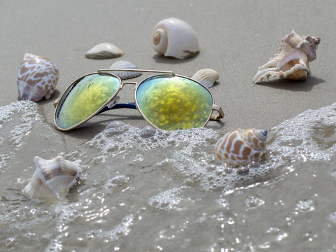 Yellow Sunglasses On The Sandy Beach.  