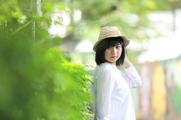 Asian young woman thinking and looking travel concept portrait with green tree background