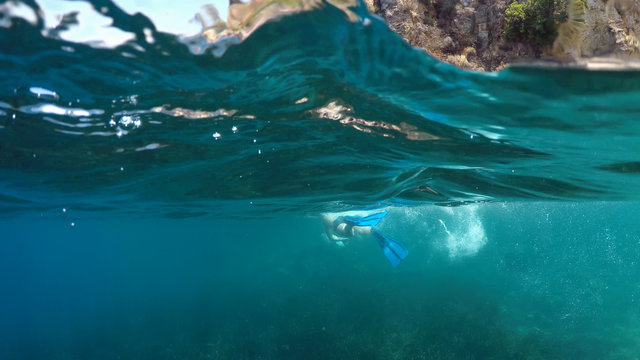 swimmer in flippers dives into the sea