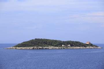 Fototapeta na wymiar Island with small house on rocks, Photo of small island with boats and blue sea in the background