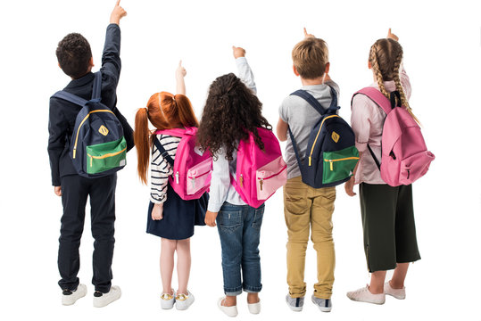 back view of multiethnic children with backpacks pointing at copy space isolated on white