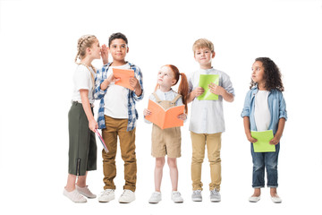 Obraz premium happy multiethnic children holding textbooks and standing together isolated on white