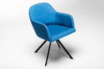 Studio shot of stylish chair with blue fabric top and triangular metallic legs on white