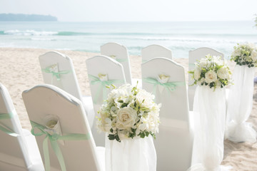 Wedding chair decorated with flowers on the beach.