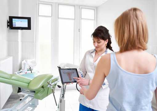 Female gynecologist showing uterus picture on a digital tablet to her patient during appointment at the clinic copyspace gynecology feminine health professionalism medical technology device gadget.