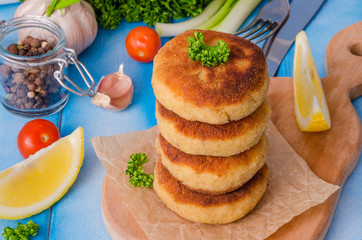Stack of fish cutlets on a wooden board