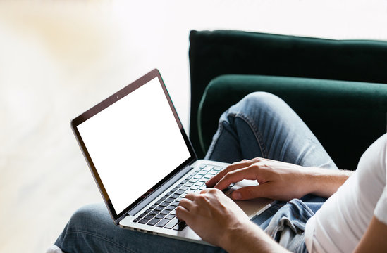 Man's Hands Using Laptop With Blank Screen On Desk In Home Interior. Work Concept