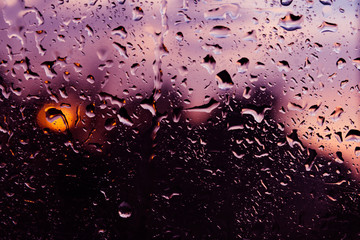 Background, wet fogged glass film with drops of water and dew during the rain at sunset