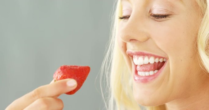 Close-up Of Beautiful Woman Eating Strawberries In Bowl