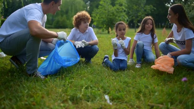 Experienced environmentalists chatting with children over voluntary work
