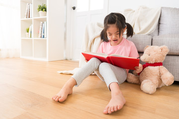 closeup of children read the story to her teddy