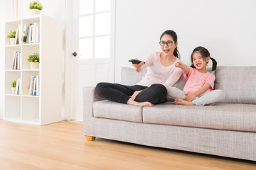 young asian mother holding a remote control