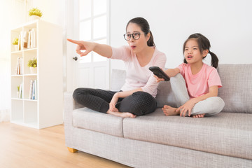 daughter holding a remote control to pick channel