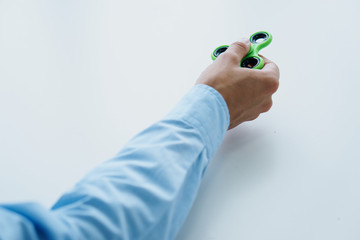 A man's hand holds a spinner on a white isolated background
