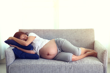 Fototapeta premium woman pregnant sleeping on sofa furniture in living room