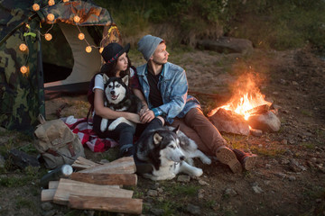 Couple with dogs in tent on nature