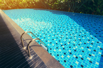 blue swimming pool around with green nature garden