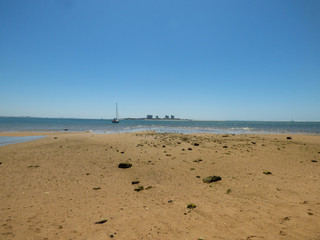Comenda beach with shallow water in Setubal, Portugal - Troia peninsula in the background