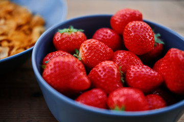 Delicious strawberry in a cup on a wooden desk.