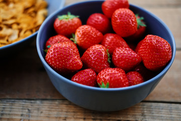 Delicious strawberry in a cup on a wooden desk.