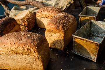 Fresh bread and baking dish. Metallic shapes. Side view. Bread for breakfast.
