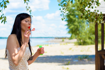 Tender woman with bubbles. Pretty girl in lace clothes on vacation, nature background 