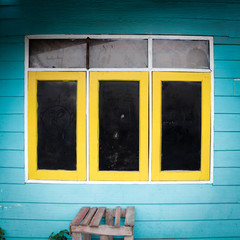 The old windows yellow and black color with wall bright blue color in vintage style for a background.