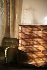 An antique chest of drawers in the ascetic interior of the room