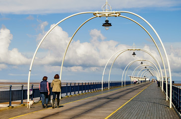 People walking along bridge, pier