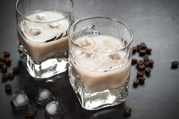 Coffee liqueur in glasses with ice and coffee beans.