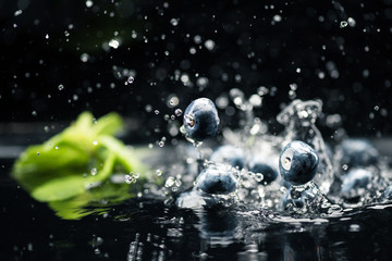 Fototapeta na wymiar ripe blueberries dropping in water
