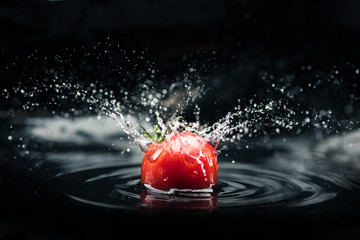 fresh tomato falling in water