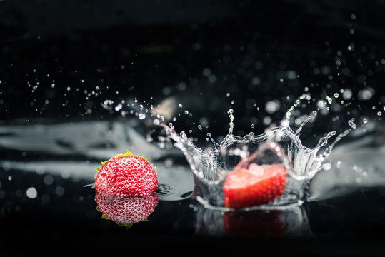 Ripe Strawberries Falling In Water